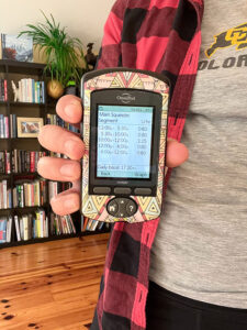 girl holding up omnipod PDM to show basal rates