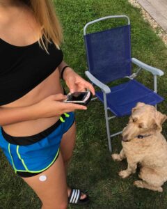 girl with type 1 diabetes using omnipod insulin pump PDM with godlendoodle in background