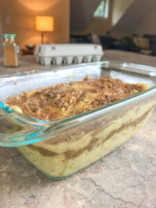 batter of cinnamon swirl zucchini bread in glass loaf pan so you can see layering