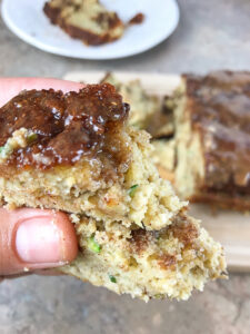 cinnamon swirl zucchini bread being held in hand with bite taken out of it